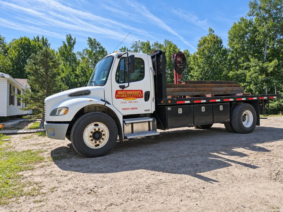 Northwoods Homesetters branded work truck carrying placement equipment